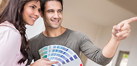 Young couple holding a paint swatch book for home decorating.