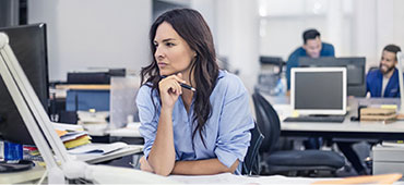 Woman sitting in front of computer in an office environment.