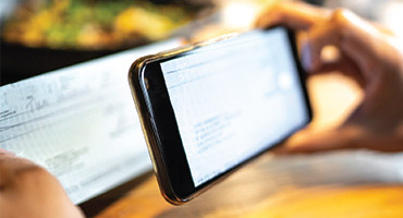 Person making a deposit using their smart phone and banking app.